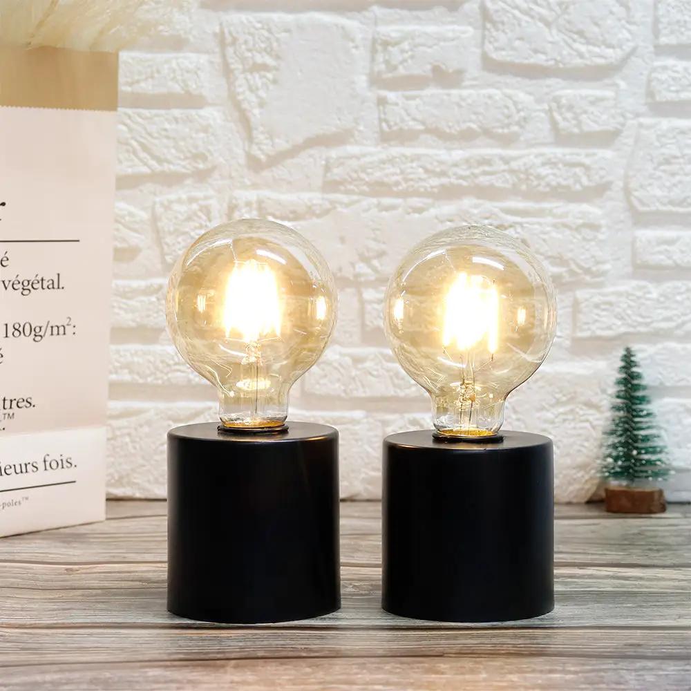 7-inch tall black battery-powered table lamps set of 2 with clear glass bulbs on black cylindrical bases