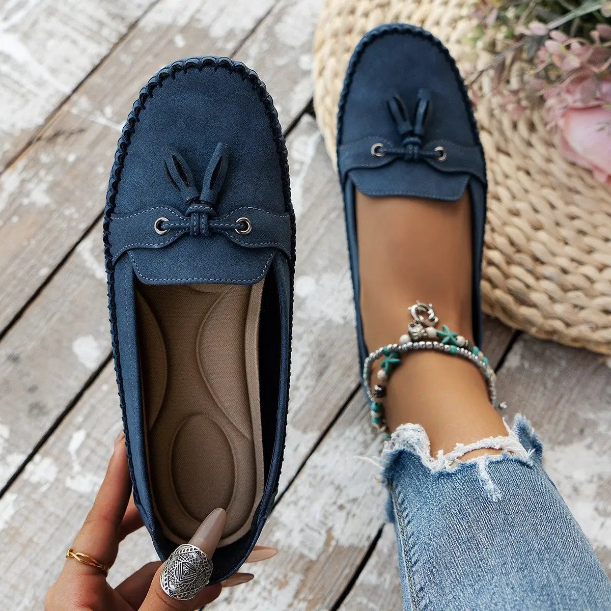 Women's navy blue round-head loafers with tassel detail and non-slip cushioned insole.