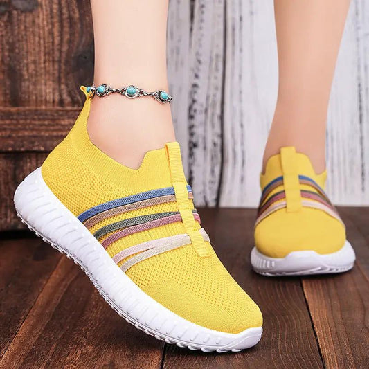 Women's yellow breathable-mesh slip-on sneakers, a pair, with white sole and multicolor side stripes.