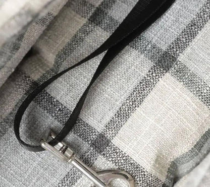 Car pet travel bag with black strap and silver metal clip on grey plaid fabric.