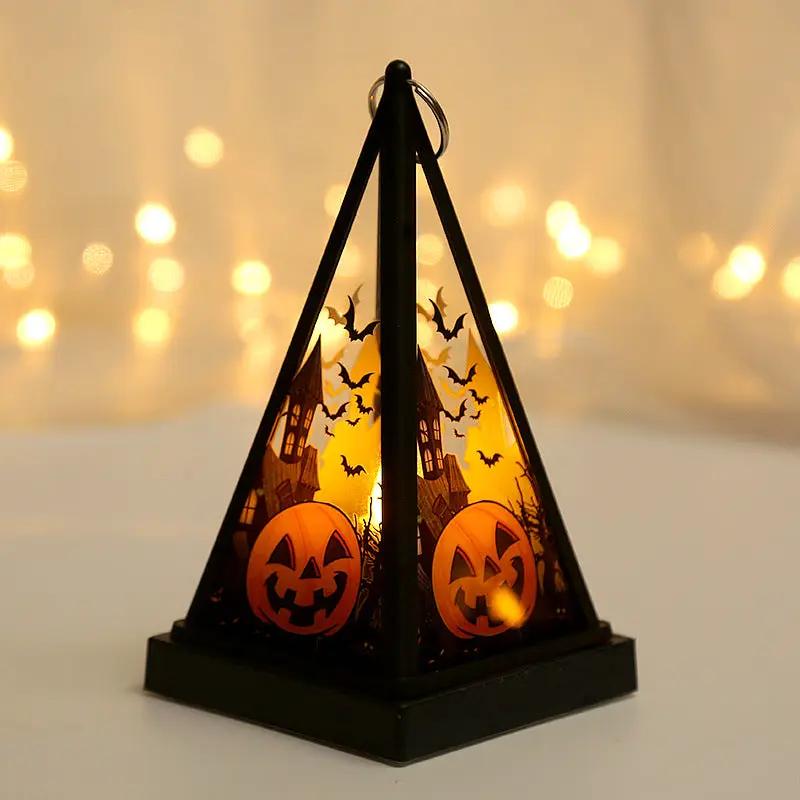 Halloween pumpkin lantern with bats and haunted-house silhouettes, black pyramid frame, warm glow desktop decoration