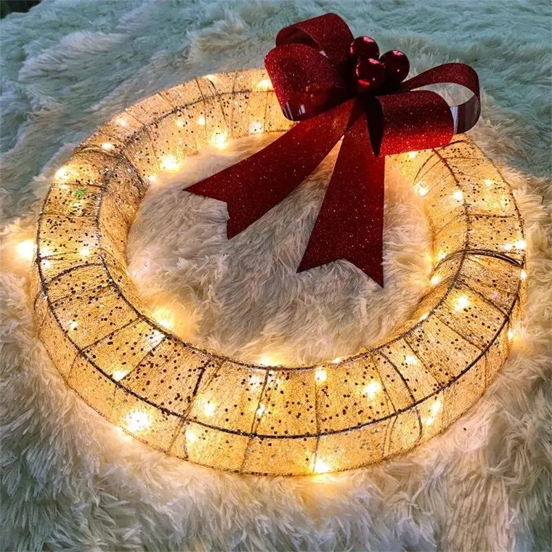 50 cm metal Christmas wreath with warm LED lights, gold glitter finish, and a large red bow