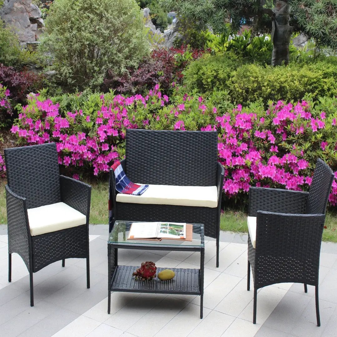 4 pc rattan patio furniture set from AdTec in black wicker with cream cushions and a glass-top coffee table