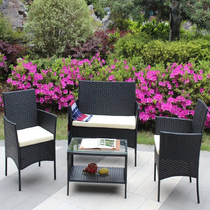 4 pc rattan patio furniture set from AdTec in black wicker with cream cushions and a glass-top coffee table