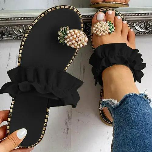 Pineapple Pearl Beach Slides, black flat-toe sandals with ruffle strap and pineapple embellishments; 2 slides shown.