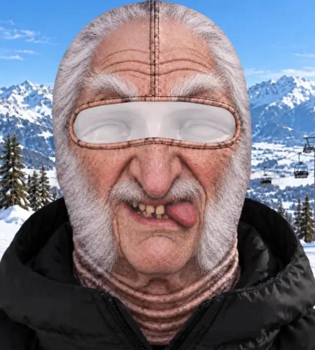 AdTec balaclava ski mask in tan with eye slit, worn by man in snowy mountain scenery.