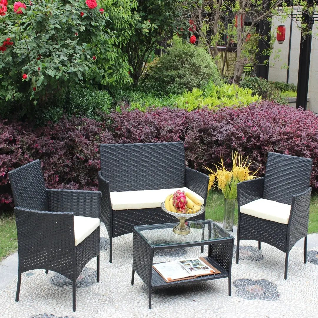 4-Piece Rattan Patio Furniture Set by AdTec with a glass-top table and beige cushions for outdoor seating