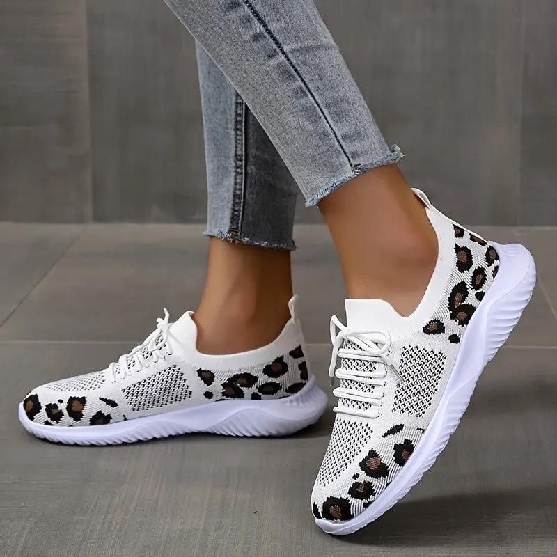 Pair of white leopard-print lace-up sneakers for women with knit mesh upper.