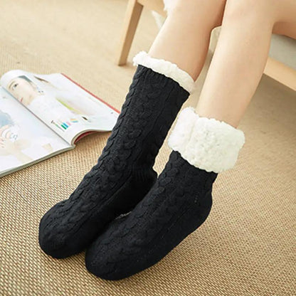 Pair of black knitted fuzzy socks with white faux fur cuffs