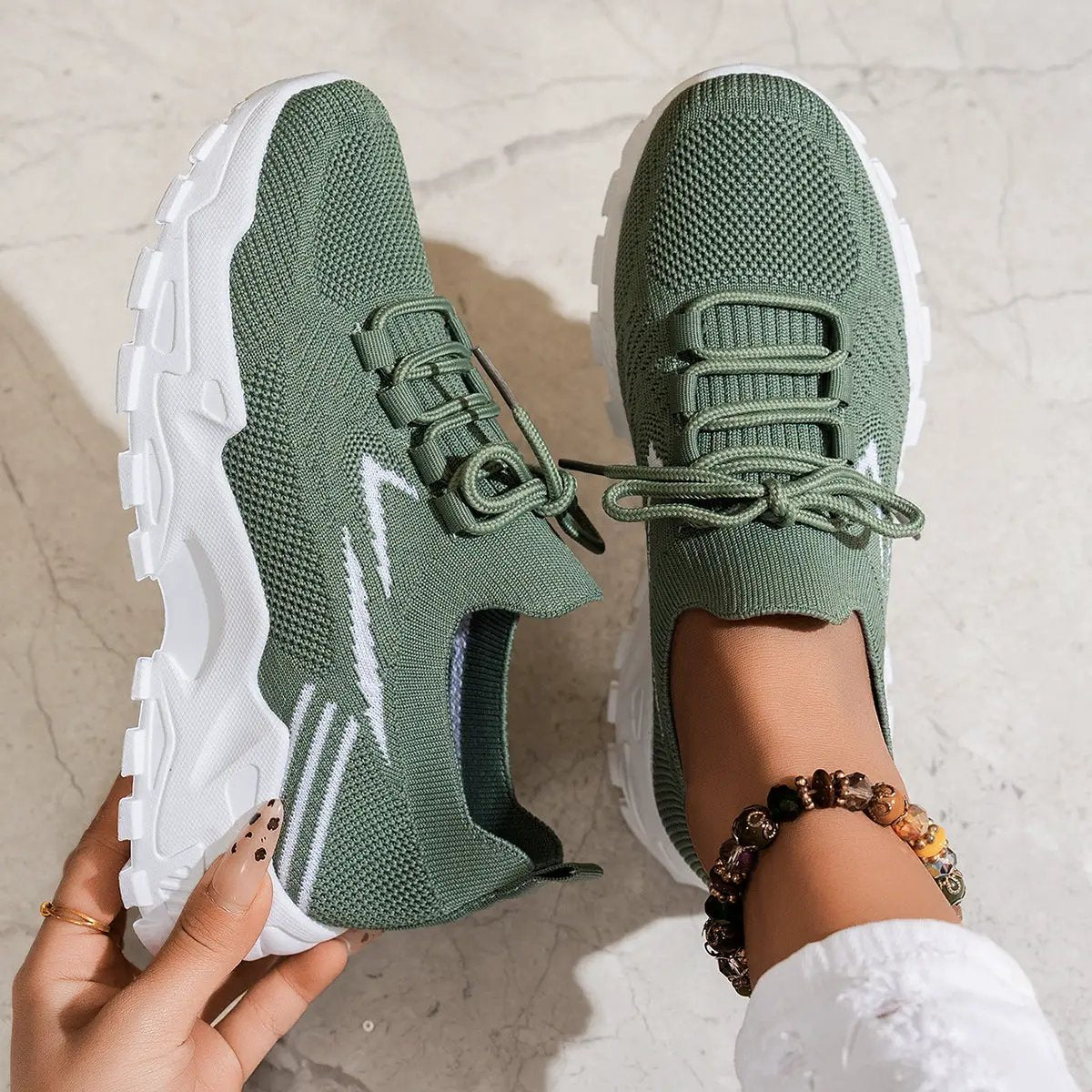 Pair of women's casual lightweight knit sneakers in olive green with white chunky soles.