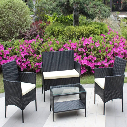 4-piece black rattan patio furniture set with beige cushions and glass-top coffee table