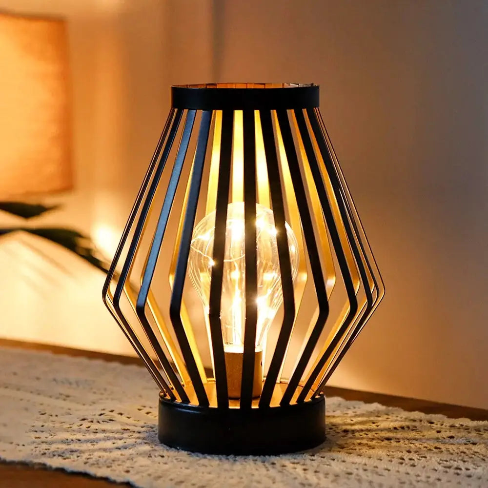 8.7H Diamond battery-powered table lamp by JHY DESIGN with black geometric metal cage and warm bulb